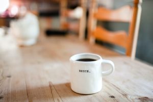A coffee cup reads "begin." This reflects concepts discussed in this blog for stressed out moms who need counseling for moms in Denver, CO with Hot Mess Counseling. 